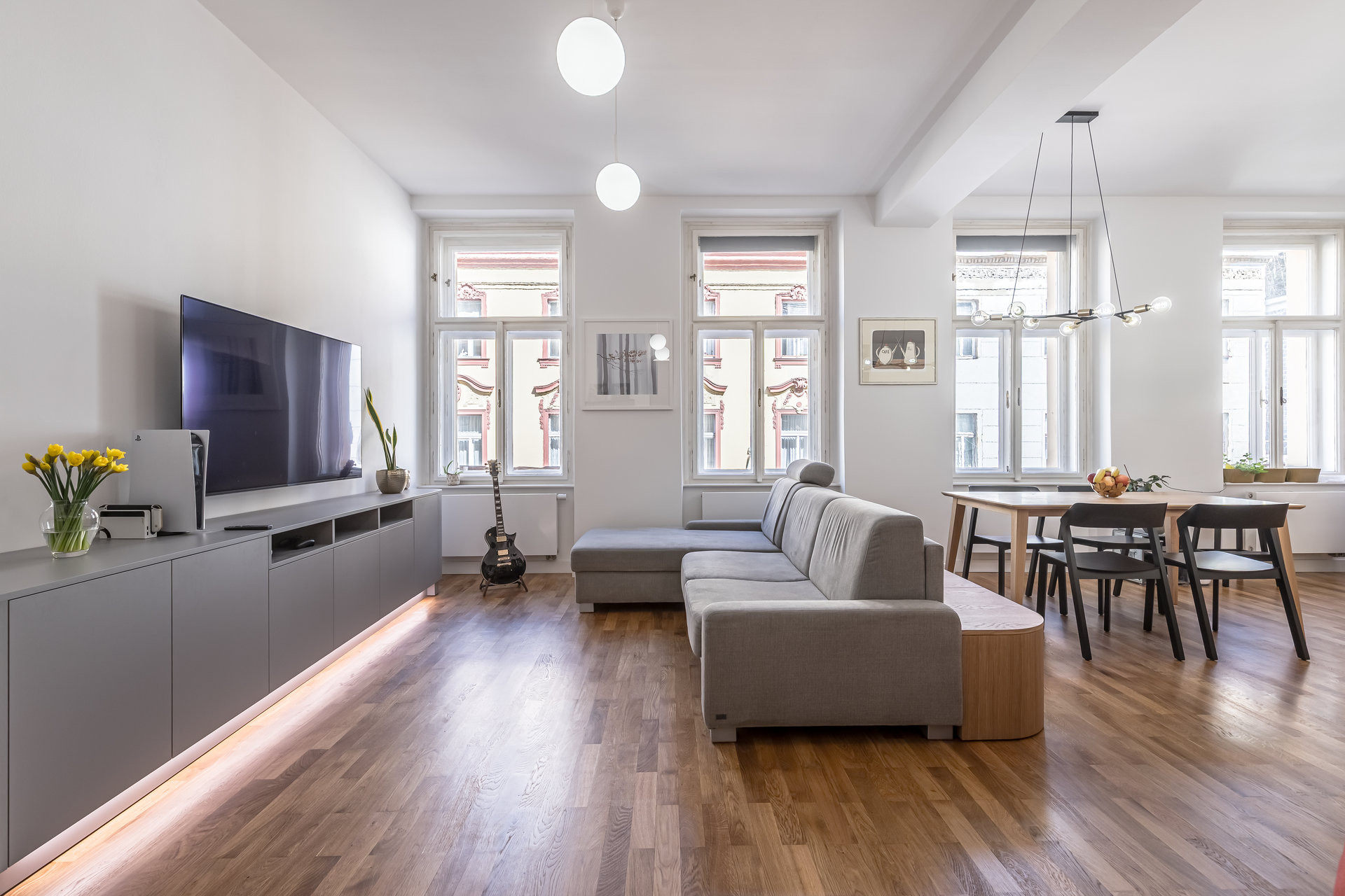 Velkorysý obývací pokoj propojený s jídelnou, knihovnou i pracovnou stále nabízí spoustu volného prostoru a nepůsobí přeplněně. (Byt v Karlíně; momentura)