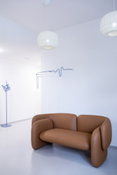 Na stěně se klikatí hravý nástěnný věšák, který připomíná křivku EKG.