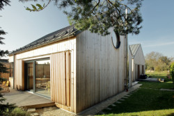 Rodinný dům na Hané, No-A Architekti: Architekti se rozhodli komponovat dům jako celek kolem atria, které z jižní strany uzavírá spojující trakt s technickou místností a koupelnami, vytvářející bariéru rušné silnici