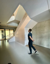 Schodiště a výtahové šachty jsou z betonu. Tady nic nenapovídá, že jsme v dřevostavbě. Prohlíží si ho architekt Branislav Kožej, jeden z autorů projektu ze studia Perspektiv. (Kanceláře postavené z CLT panelů; Studio Perspektiv)