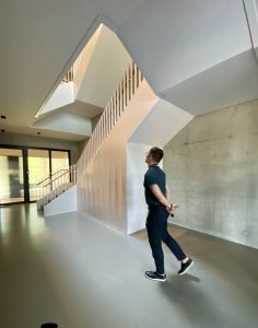 Schodiště a výtahové šachty jsou z betonu. Tady nic nenapovídá, že jsme v dřevostavbě. Prohlíží si ho architekt Branislav Kožej, jeden z autorů projektu ze studia Perspektiv. (Kanceláře postavené z CLT panelů; Studio Perspektiv)