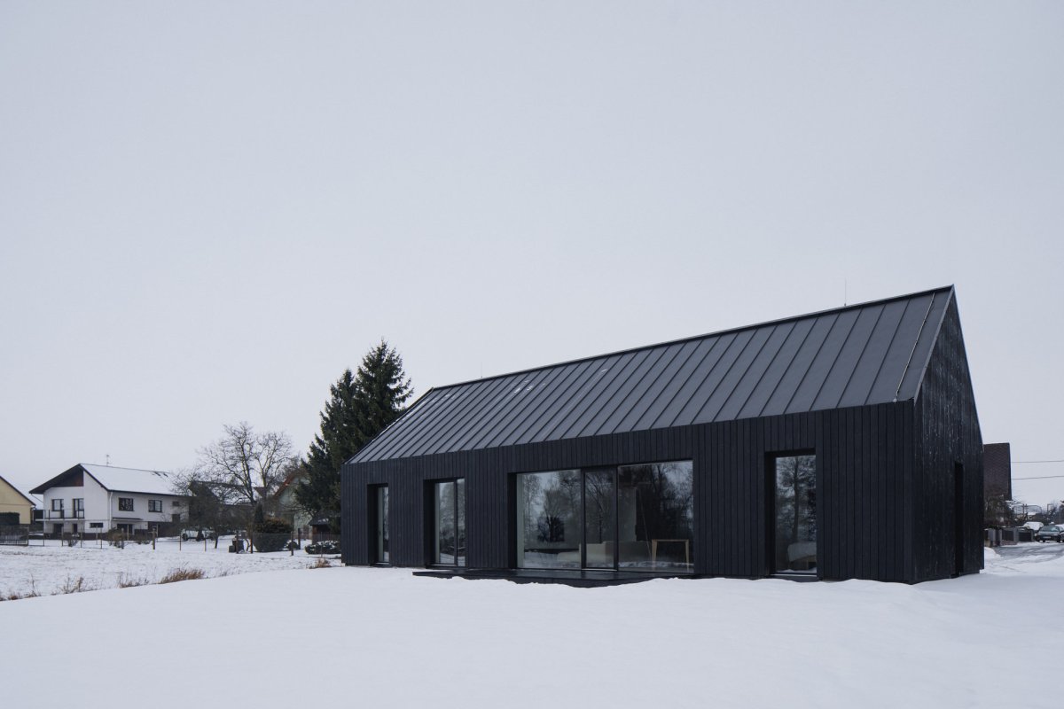 Dům je velkými prosklenými plochami propojený se zahradou. (Přízemní dům s fasádou z opalovaného dřeva; Luni architekti)