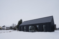 Dům je velkými prosklenými plochami propojený se zahradou. (Přízemní dům s fasádou z opalovaného dřeva; Luni architekti)