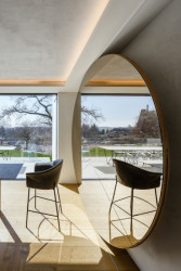 Jedna ze zvláštností kuchyně - nábytková stěna na nádobí, která se otvírá tak, že se odkoulí zrcadlo. (Vila v Trněném Újezdě, de.fakto)