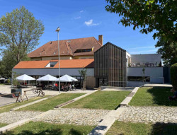 Knihovna ve Šlapanicích, Milan Podroužek a spolupracovníci: Obě jsou zakončené sedlovou střechou z pálených tašek, která jim dává tradiční vyznění a novostavba se tak dobře zapojuje do kontextu svého nejbližšího okolí