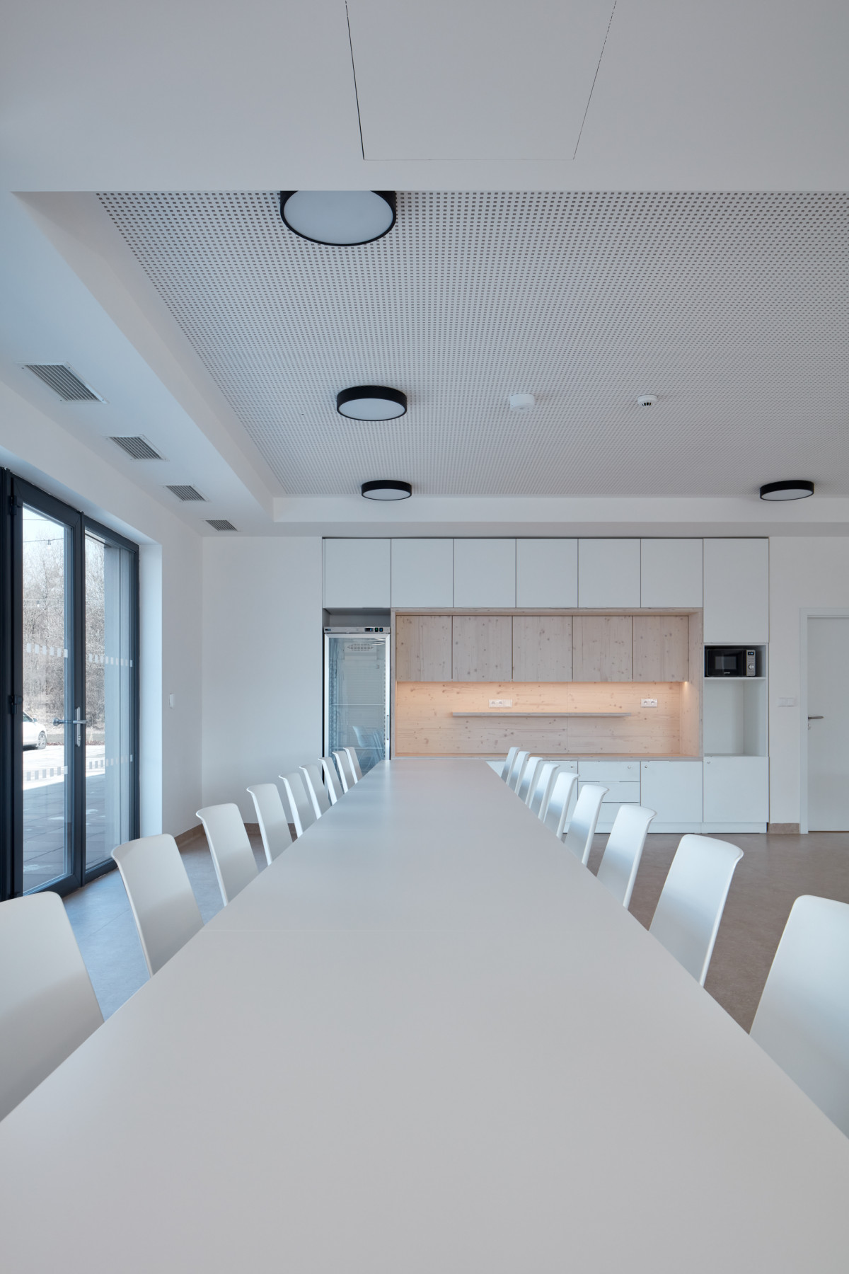Pohled do jídelny s kuchyní (Dětská léčebna se speleoterapií v Ostrově u Macochy; Adam Rujbr Architects)