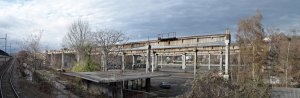 Panoramatický pohled na skládku hotových výrobků z peronu nádraží Praha-Holešovice. V popředí se nachází vrátnice expedice.