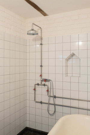 Dříve využívaný chlívek teď funguje jako technické zázemí sousedícího rodinného domu a zároveň malé wellness. (Terasa a zázemí ve stodole; tamti_architekti)