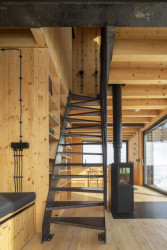Detaily, stejně tak i ocelové schodiště, které propojuje přízemí a patro s ložnicemi, jsou tmavé jako exteriér chaty