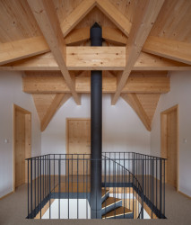 V podkroví si můžete vychutnat pohled na masivní dřevěné trámy, které přiznaně prochází interiérem a dodávají mu sebevědomé charisma.