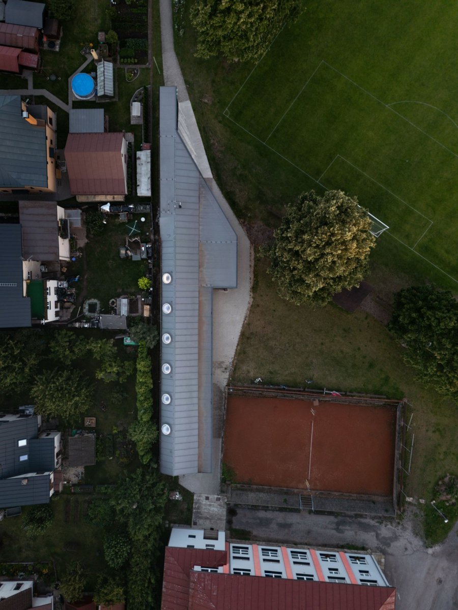 Objekt je podlouhlý a ze strany uzavírá studenecký sportovní areál. (Zázemí sportovního klubu ve Studenci, ateliér CHRAMA)