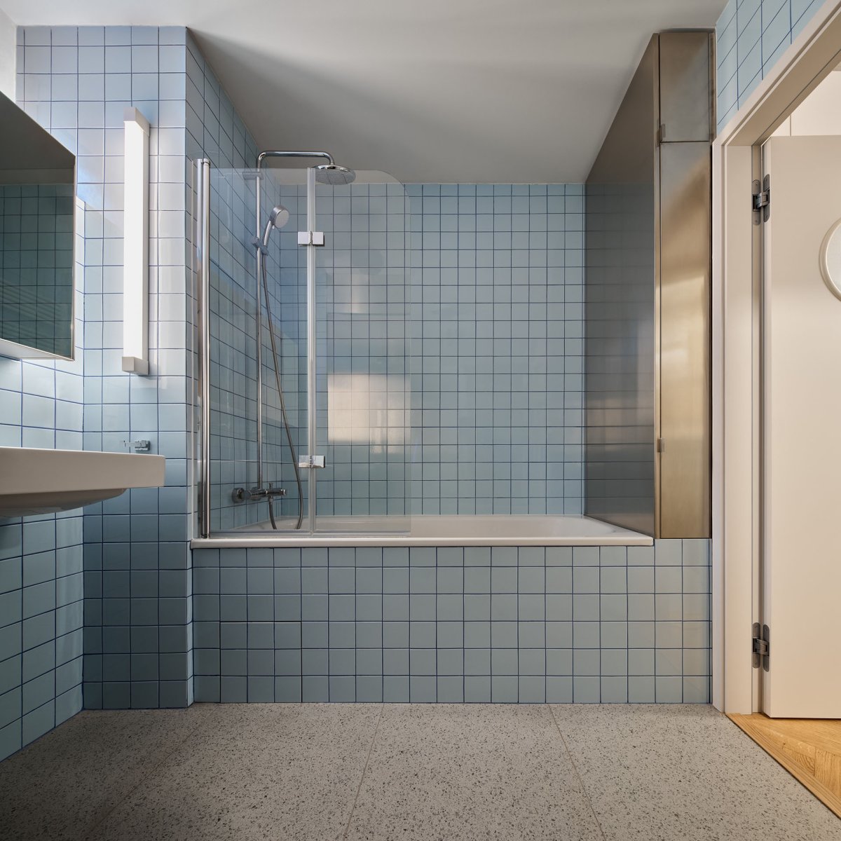 Pro nábytek v koupelně architekt zvolil povrchovou úpravu z nerezového plechu. (Rekonstrukce bytu ve Vršovicích, Amulet architekti)
