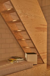 Víkendový dům "Das Glashaus" v Německu, Sigurd Larsen: Do prostoru pod schodištěm architekt umístil pohovku.