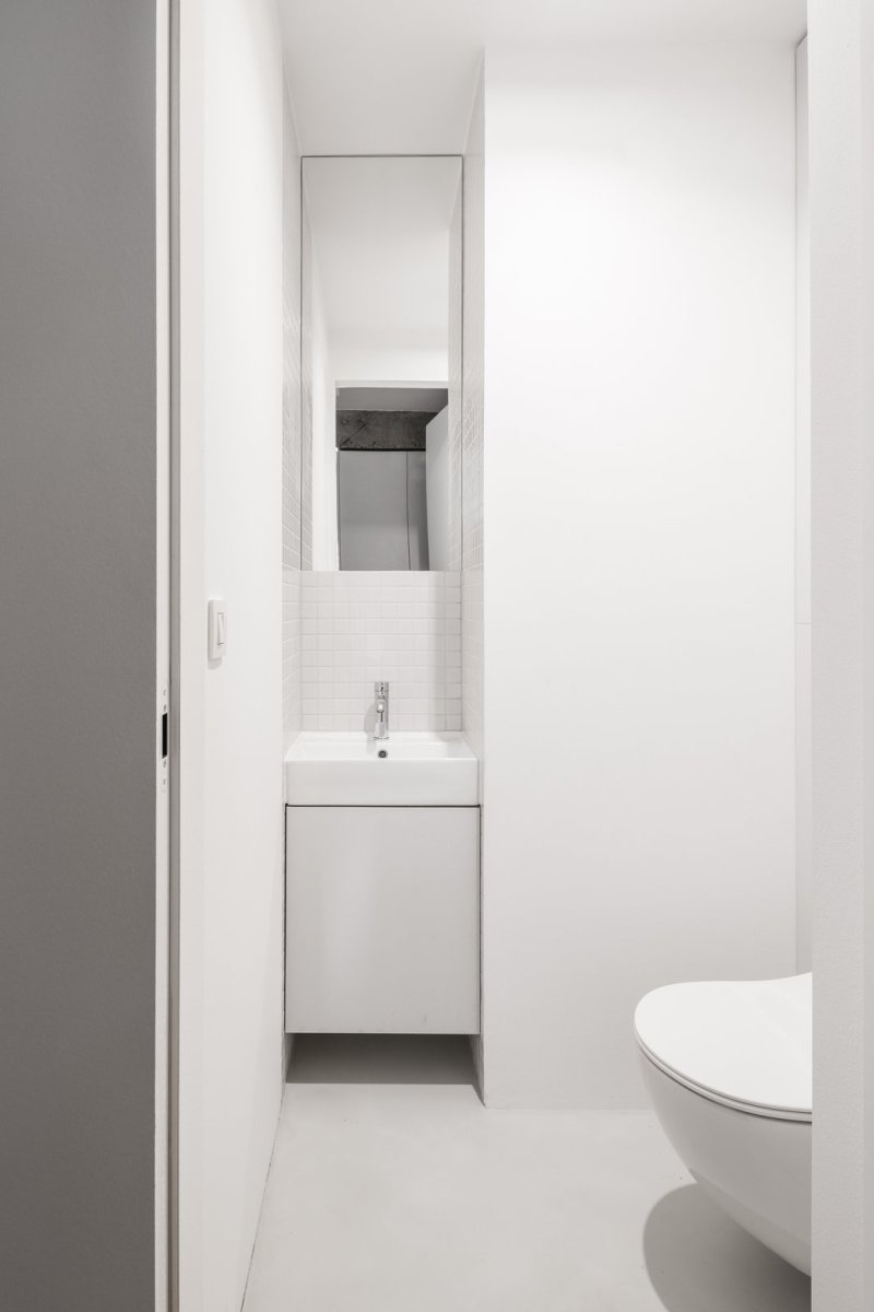 Mikrocementové povrchy na toaletě (Rekonstrukce bratislavského panelového bytu; Abrama architekti)