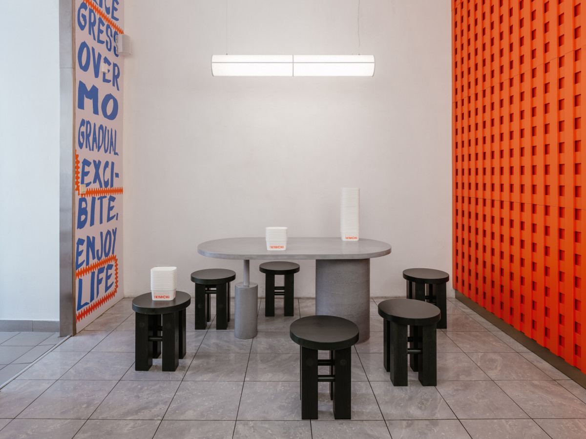 Dispozice reaguje na různorodý provoz restaurace – nabízí posezení u výloh, společný betonový stůl i možnost jídla s sebou. (The Kimchi; SOA architekti)