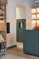 Příjemnou a přirozenou atmosféru prostoru dodává použití kombinace světlého dřeva a odstínů bílé. (KRO Vršovice, NEUHAUSL HUNAL)