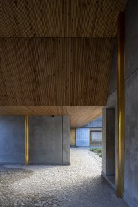 Beton zjemňuje dubové dřevo a mosazné detaily. (Åstrup Have, NORRØN Architects)