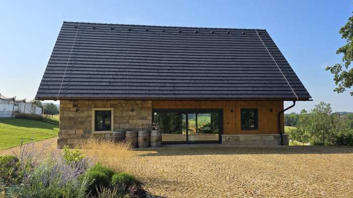 Rozsáhlá prosklená plocha a velká okna v roubence opticky rozšiřují interiér a navozují pocit volnosti.