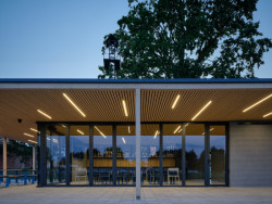 Díky prosklené rozevírací stěně se dá prostor otevřít a tak je možné fotbalovým kláním přihlížet i odtud. (Sportovní areál SK Planá, PROAM ARCHITEKTI)