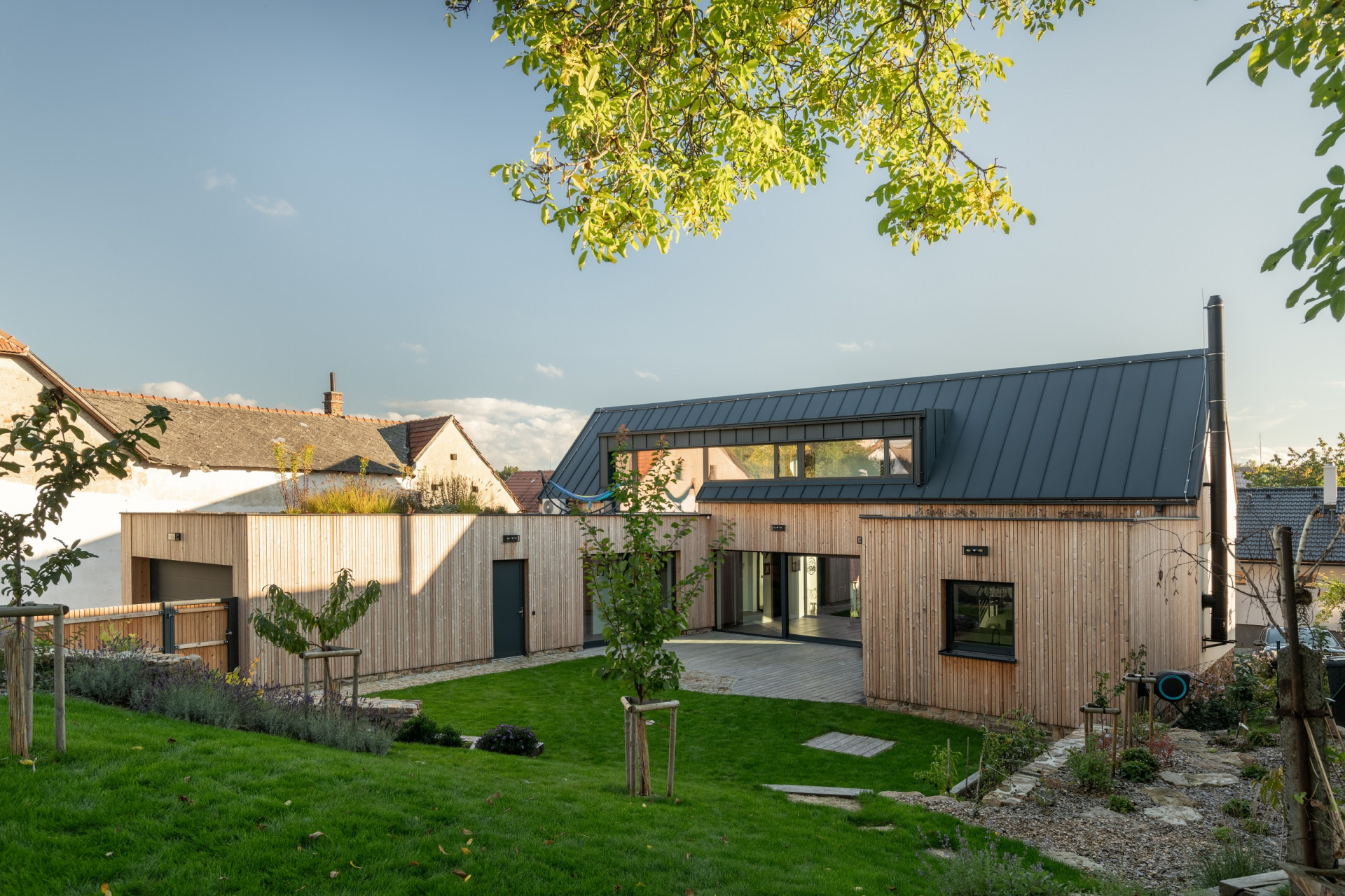 Rodinný dům v Bystřici nad Perštejnem, studio AEIOU: Součástí realizace byla také úprava zahrady. V té se nachází například záhony pro bylinky a zeleninu, do kterých se dá pohodlně vstoupit přímo z kuchyně