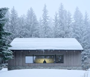 Stavba pracuje s pro lokalitu typickým kamenným soklem, fasádou obloženou modřínem a sedlovou střechou. (Chalupa Na Kukačkách; edit! architects)