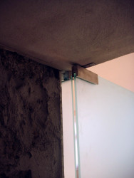 Kotvenie presklenných dverí. Foto pred montážou dreveného obkladu stien.