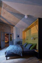 Postel je postavená doprostřed ložnice.