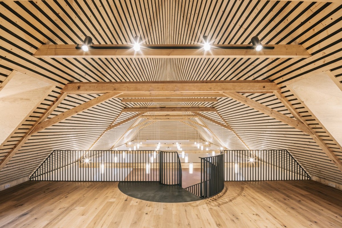 Galerie již v sýpce byla, nově ji však doplnilo centrální schodiště. To přirozeně odděluje převýšený sál od části s barem a galerií, aniž by narušovalo otevřený charakter prostoru. Jak doplňuje architektka Pavla Feistnerová, schodiště se osvědčilo také jako místo pro svatební proslov či organizaci hostů.