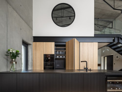 Kuchyně z dubového dřeva změkčuje beton a ocel haly. (Industriální přestavba rodinného domu; Atel!er)