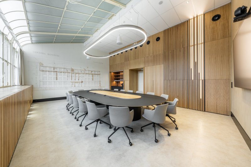 V pozadí je akustická stěna s kopií historického výkresu. (Zasedací místnost Státní tiskárny cenin; JKH Architects)