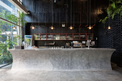 Stejný motiv skládání dřevěných bloků na sebe je použit i u stěny baru. (Restaurace Pizza 4P’s v Hanoji od česko – vietnamského studia ODDO)