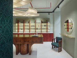 Showroom kosmetiky v Karlíně, P E T R I K + K O T R C & Nora Sopková: Podlaha v pískovo-šedé barvě a světle zelená výmalba působí klidným dojmem a nechávají vyniknout solitérní kusy nábytku