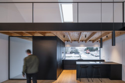 Byly použité dřevěné trámy místo ocelových. V interiéru jsou viditelné. (Přízemní dům s fasádou z opalovaného dřeva; Luni architekti)