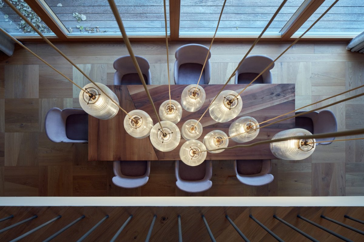 Interiéry vily v Klánovicích, KURZ architects: Nad jídelním stolem visí dlouhé lustry, dřevěná podlaha je zase složená z čtvercových kazet, podobných těm, které známe ze zámků.