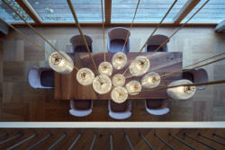 Interiéry vily v Klánovicích, KURZ architects: Nad jídelním stolem visí dlouhé lustry, dřevěná podlaha je zase složená z čtvercových kazet, podobných těm, které známe ze zámků.