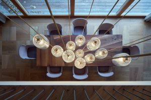 Interiéry vily v Klánovicích, KURZ architects: Nad jídelním stolem visí dlouhé lustry, dřevěná podlaha je zase složená z čtvercových kazet, podobných těm, které známe ze zámků.