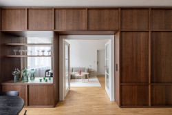 Truhlářsky zpracovaná knihovny navazující na kuchyň (Byt Mariánska v Bratislavě, NOIZ architekti)