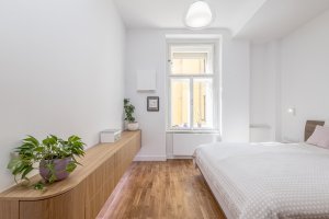 Světlá ložnice pro odpočinek po každodenním shonu ve velkoměstě (Byt v Karlíně; momentura)