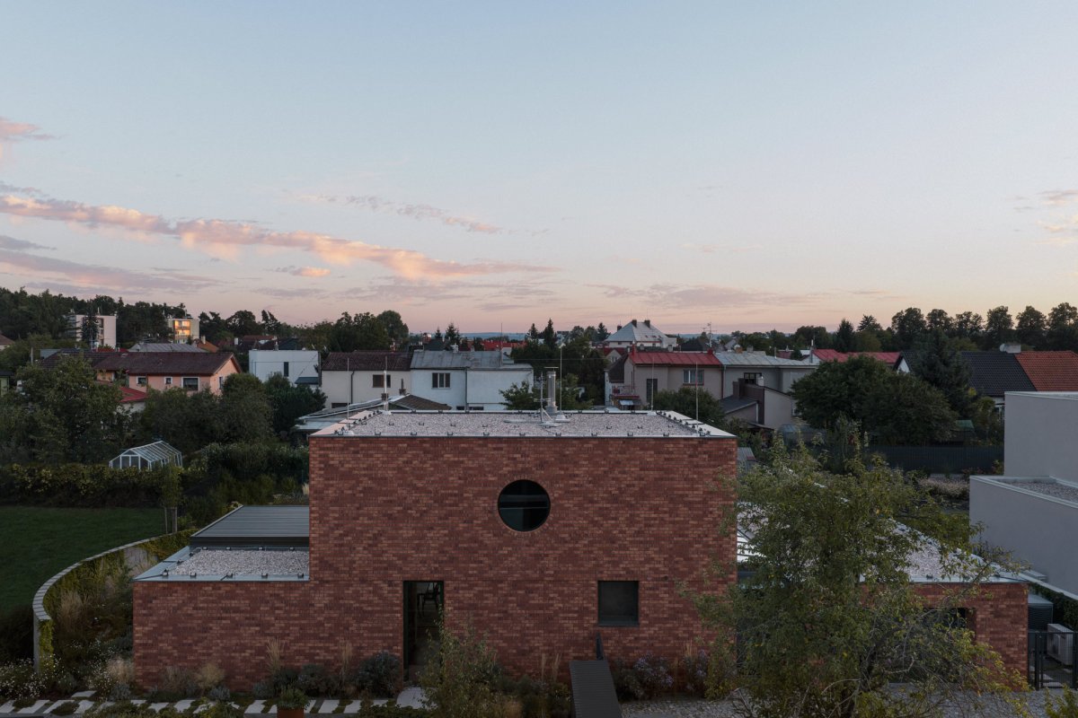 Všude kolem je různorodá zástavba, tento dům si ale nikdo nesplete. (Cihlový dům v Pardubicích; architekti Jakub Dvořák a Michal Bílek)