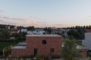 Všude kolem je různorodá zástavba, tento dům si ale nikdo nesplete. (Cihlový dům v Pardubicích; architekti Jakub Dvořák a Michal Bílek)