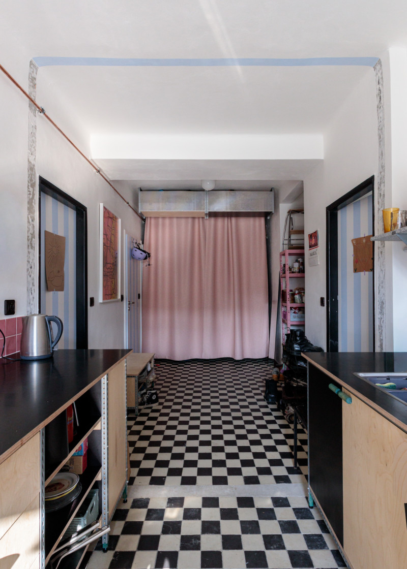 Pohled směrem k růžovému závěsu, za nímž se nachází vstup do bytu. (Byt v Libni; batyré)