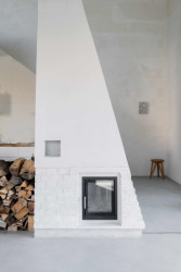 Srdcem obytného prostoru je převýšený krb. (Rodinný dům s ateliérem, Helga Blocksdorf Architektur)