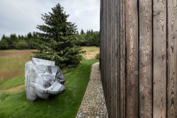 Na zahradě jim leží kovová socha, kterou si můžou prohlédnout kolemjdoucí. (OK PLAN ARCHITECTS, Rodinná bouda)