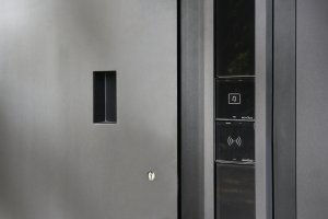 Vstupní dveře Schüco AD UP 90  se zapuštěným madlem a ovládacím panelem s čtečkou otisků prstu pro vstup.