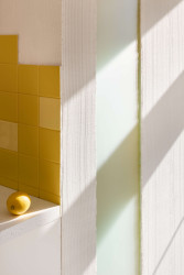 Obklady schválně nedochází až do rohů a tvoří tak hravou mozaiku. (Byt pro malířku v Praze-Holešovicích od Plus One Architects)