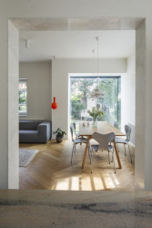 Kuchyně se otevírá směrem k jídelnímu stolu, od kterého je výhled do zahrady novým proskleným arkýřem. (Rekonstrukce prvorepublikové vily v Praze, Lenka Míková Architekti)