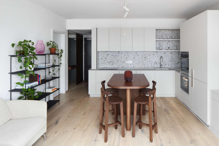 Pohled do hlavního obytného prostoru, kterému dominuje masivní dubový ostrůvek. (Interiér bytu Karlín; PANIKHORN)