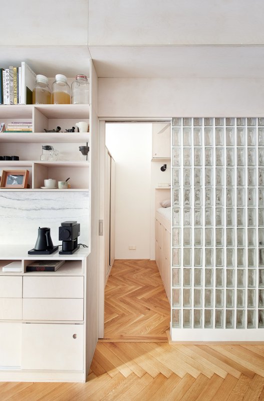 Knihovnou do ložnice. Světlo sem propouští luxfery. (Rekonstrukce bytu na Vinohradech, Markéta Bromová architekti)