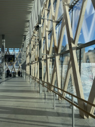 Vlastní zkušenost: Prostorovou strukturu ze dřeva chrání před povětrností skleněná fasáda. Díky tomu je po patnácti letech stále v dobré kondici. (Vlaková stanice Umeå Östra, White Arkitekter)