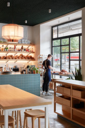 Příjemnou a přirozenou atmosféru prostoru dodává použití kombinace světlého dřeva a odstínů bílé. (KRO Vršovice, NEUHAUSL HUNAL)